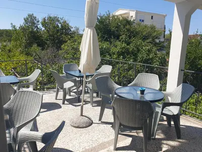 a patio with tables and chairs and an umbrella at House Kraja in Ulcinj