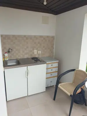 a kitchen with a sink and a chair in a room at House Kraja in Ulcinj