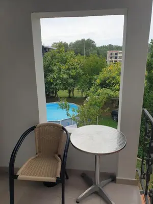 a table and chair on a balcony with a view of a pool at House Kraja in Ulcinj