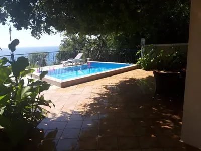 a swimming pool with a chair next to the ocean at Apartment Sofia in Sutomore