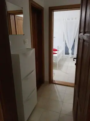 a kitchen with a refrigerator and a door to a room at Apartmani Vukmanovic in Čanj