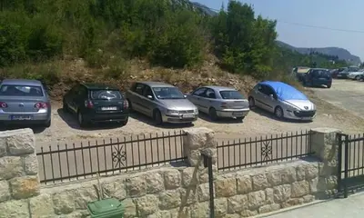 a group of cars parked in a parking lot at Apartmani Vukmanovic in Čanj