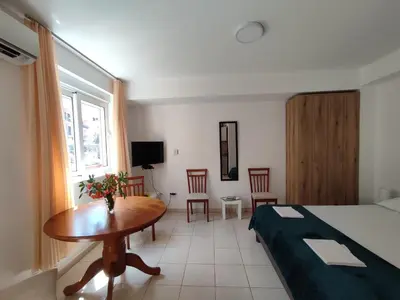 a hotel room with a bed and a table and chairs at Studio Apartman Radimir in Kotor