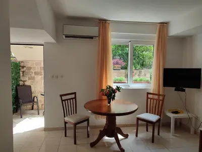 a dining room with a table and chairs and a window at Studio Apartman Radimir in Kotor