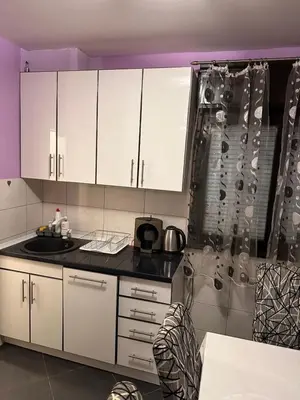 a kitchen with white cabinets and a sink and a shower at Apartment Branka in Budva