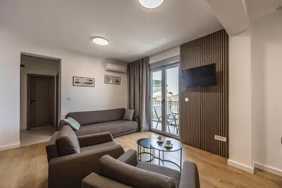 a living room with a couch and a tv at Apartments My Przno in Sveti Stefan