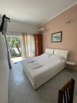 a bedroom with a large bed and a large window at Apartments SoleMar2 in Sutomore