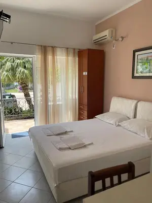 a bedroom with a large bed and a balcony at Apartments SoleMar2 in Sutomore