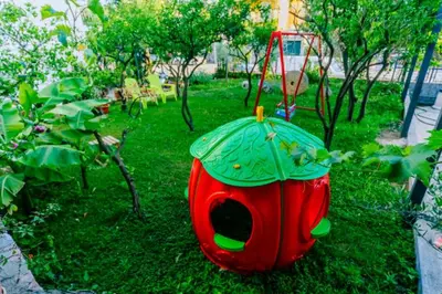 a red and green bird house with an umbrella on the grass at Apartments SoleMar2 in Sutomore