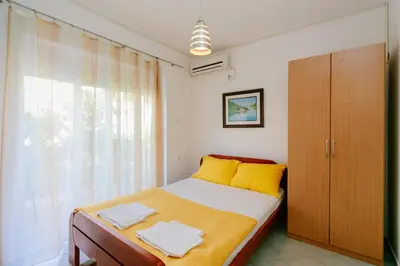 a bedroom with a bed and a large window at Apartments SoleMar2 in Sutomore