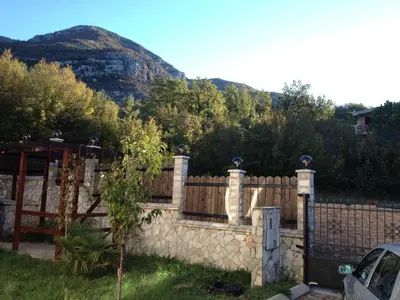 a stone fence with a mountain in the background at Villa Coast of Montenegro in Bar
