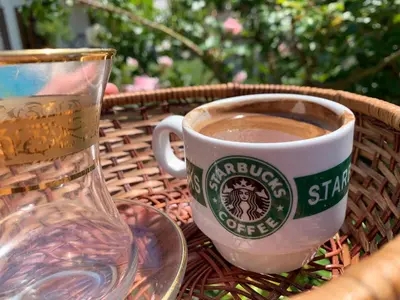 a cup of coffee sitting on a table next to a glass at Villa Coast of Montenegro in Bar
