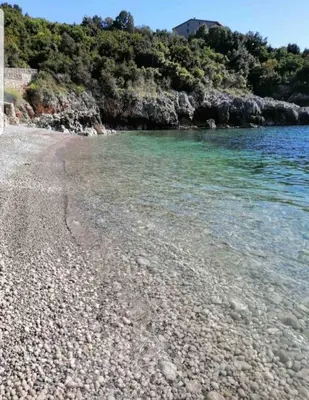 a beach with rocks and the water at Villa Persik in Utjeha