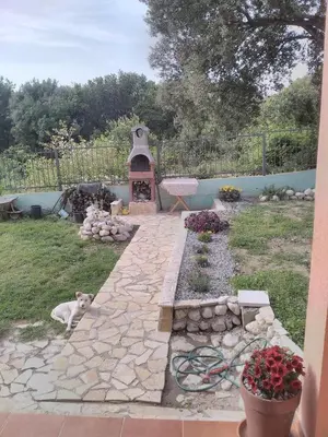 a dog laying in a yard with a stone walkway at Villa Persik in Utjeha