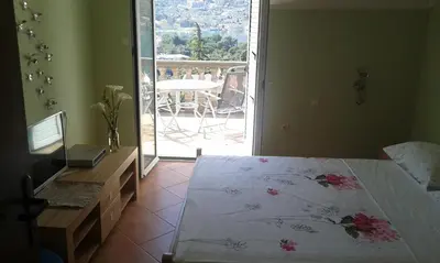 a bedroom with a bed and a view of a patio at Apartment Ivan in Kotor