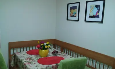 a table with two plates and a vase with flowers on it at Apartment Ivan in Kotor