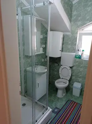 a bathroom with a toilet and a glass shower at Apartment Ivan in Kotor