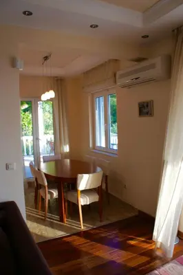 a dining room with a table and chairs at Cezar Holiday Home in Sveti Stefan