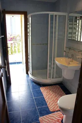 a bathroom with a shower and a toilet and a sink at Cezar Holiday Home in Sveti Stefan