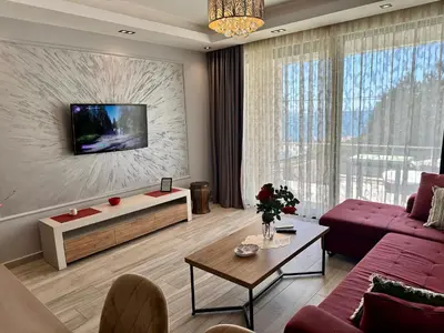 a living room with a couch and a tv on a wall at Apartment Ema Star in Utjeha
