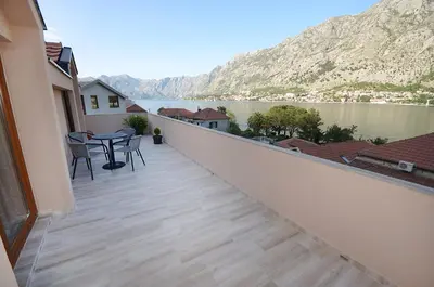a balcony with a table and a view of a lake at Apartmani Mizdrak in Kotor