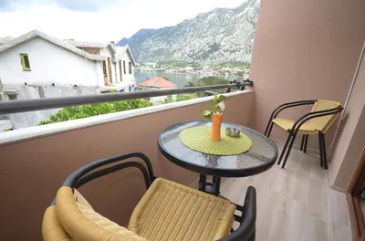 a balcony with a table and chairs and a view at Apartmani Mizdrak in Kotor