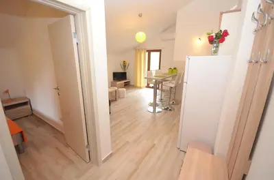 a room with a table and a white refrigerator at Apartmani Mizdrak in Kotor