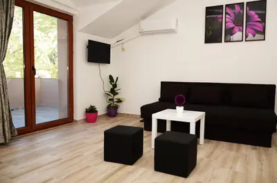 a living room with a black couch and a table at Apartmani Mizdrak in Kotor