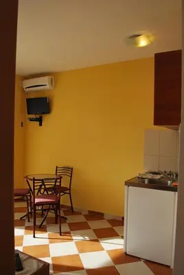 a kitchen with a table and chairs in a room at Apartments Stevanović in Dobra Voda