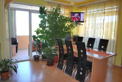 a conference room with a table and chairs and plants at Apartments Stevanović in Dobra Voda