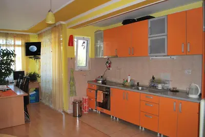 a kitchen with orange cabinets and a stove top oven at Apartments Stevanović in Dobra Voda