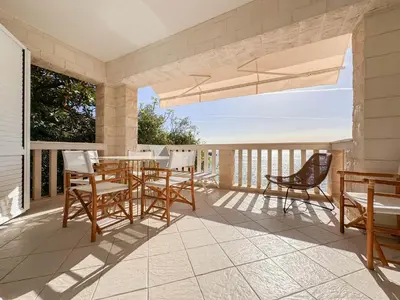 a patio with a table and chairs on a balcony at Apartment Radovic in Sveti Stefan