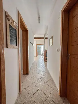 a hallway with a tile floor and a chalkboard on the wall at Apartment Radovic in Sveti Stefan
