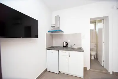 a small white kitchen with a sink and a toilet at Apartments Mika in Budva