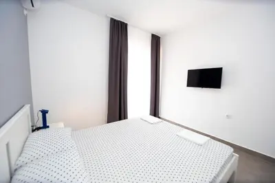 a white bed in a room with a window at Apartments Mika in Budva