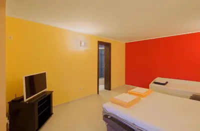 a small room with a bed and a tv at Apartments Mika in Budva