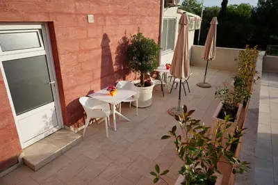 a patio with a table and chairs and an umbrella at Apartments Residence Dj in Petrovac na Moru