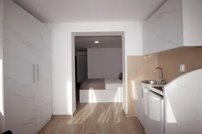 a kitchen with a sink and a bed in a room at Apartments Residence Dj in Petrovac na Moru