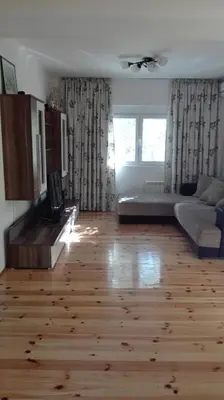 a living room with a wooden floor and a couch at Villa Nadija in Čanj