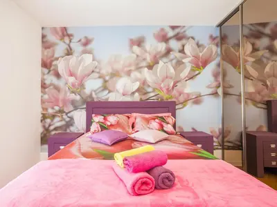 a bedroom with a pink bed with towels on it at Luxury Apartment Valentina in Budva