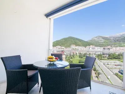 a balcony with a table and chairs and a large window at Luxury Apartment Valentina in Budva