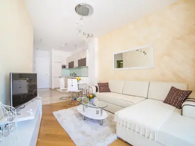 a living room with a white couch and a tv at Luxury Apartment Valentina in Budva