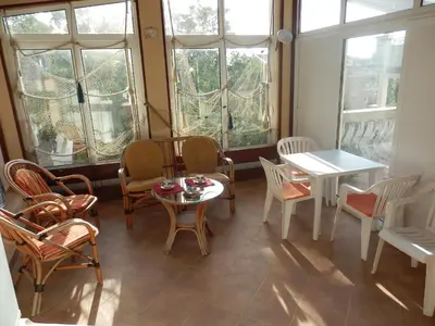 a room with a table and chairs and windows at Apartments Esperanza in Utjeha