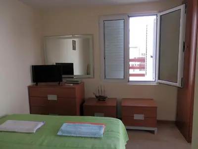 a bedroom with a bed and a television and a window at Apartments Esperanza in Utjeha