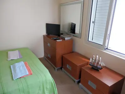 a bedroom with a bed and a dresser and a television at Apartments Esperanza in Utjeha