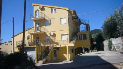 a large yellow building with stairs on it at Korolev Apartment in Budva