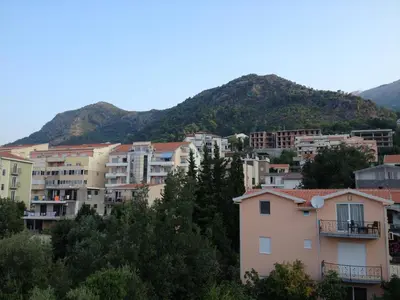 a group of buildings in front of a mountain at Korolev Apartment in Budva