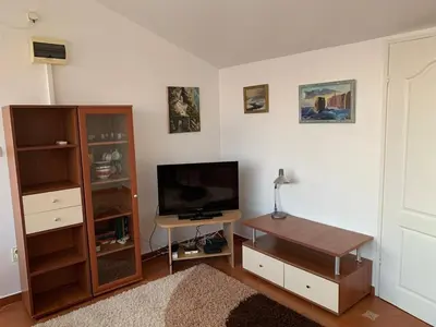 a living room with a flat screen tv and a desk at Korolev Apartment in Budva