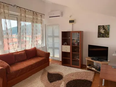 a living room with a couch and a television at Korolev Apartment in Budva