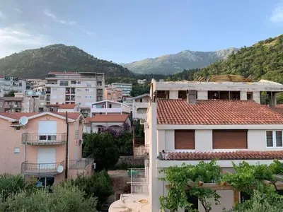 a group of buildings with mountains in the background at Korolev Apartment in Budva